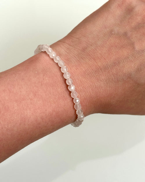 A pale pink beaded bracelet worn on a person's wrist, shown against a plain light background.