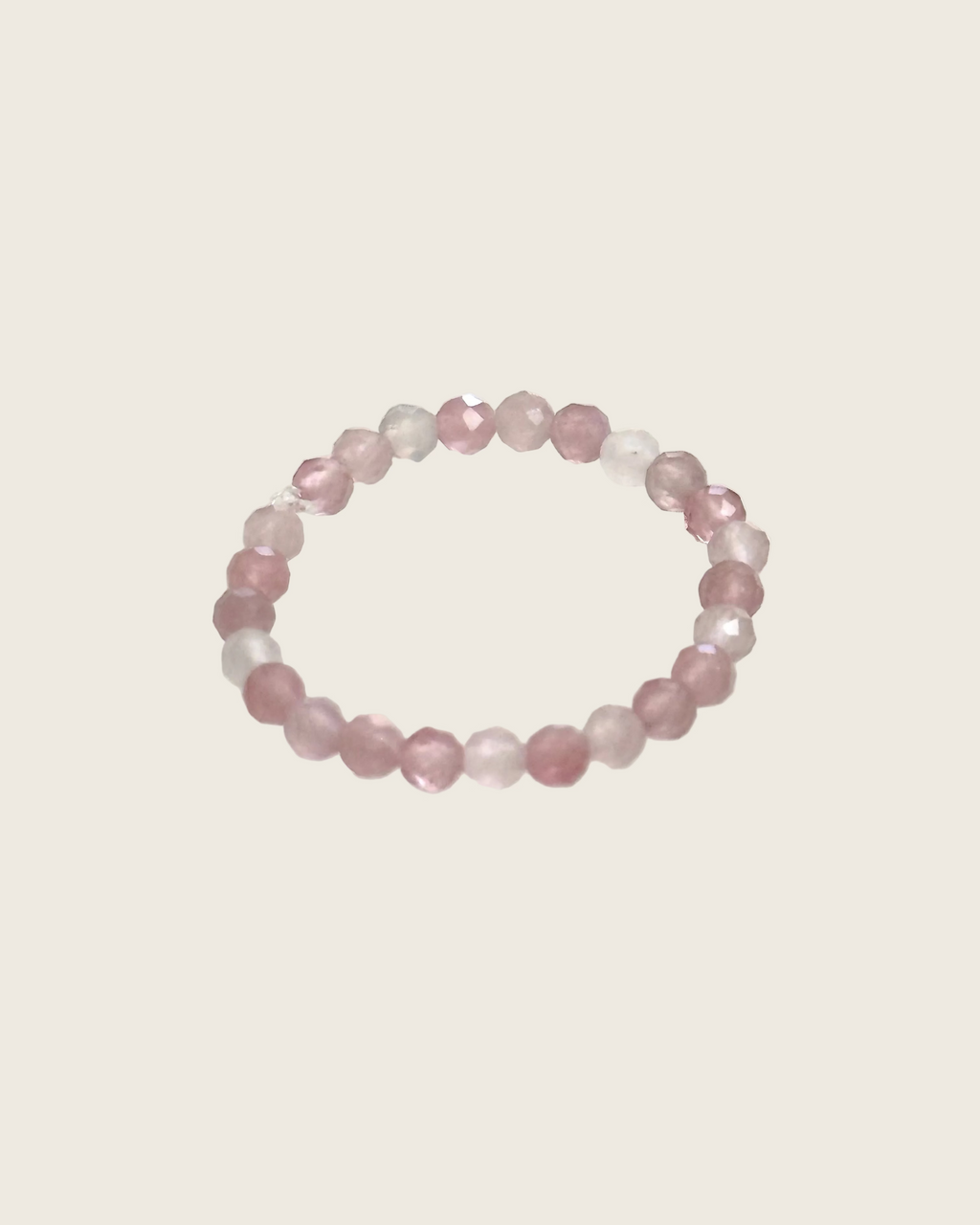 A beaded stretch ring made of faceted pink and translucent rose quartz beads, photographed on a plain white background.